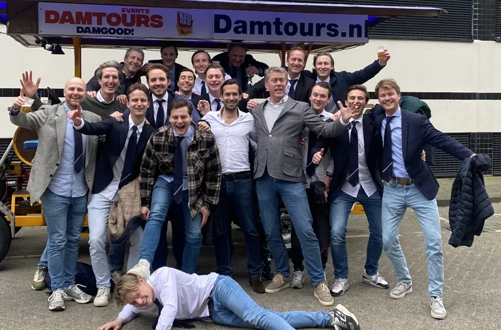 Groep gelukkige toeristen genieten van een bierfietstocht in Amsterdam met Damtours.
